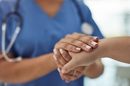 Nurse holding patient's hand