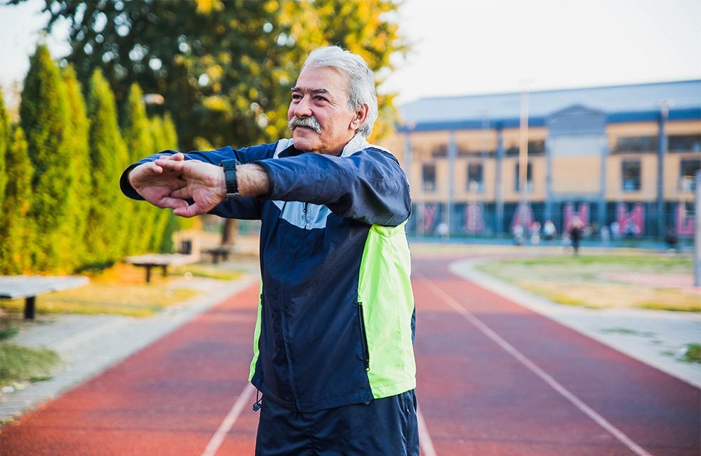 Man stretching on outdoor track