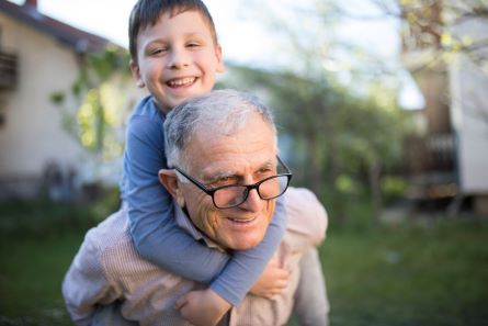 grandfather giving son a piggyback ride