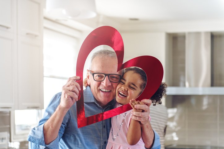 Grandfather and granddaughter posing with a heart