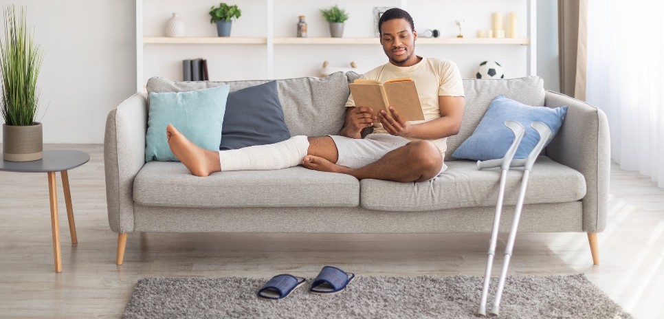 man with a broken leg sitting on a couch