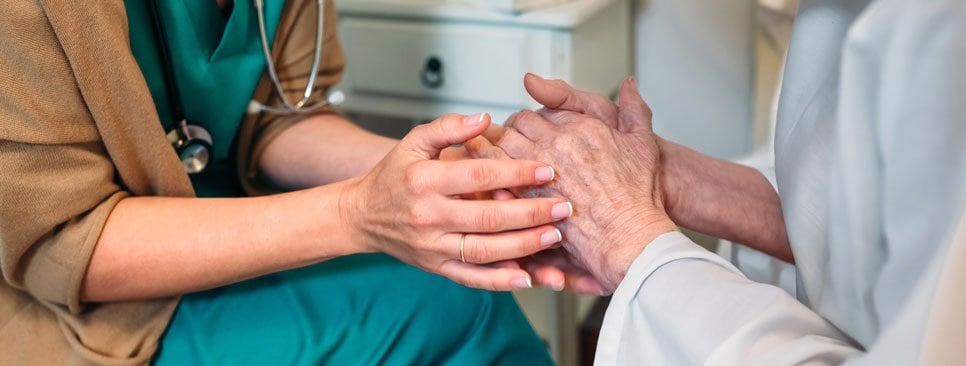 Nurse holding a patient's hands