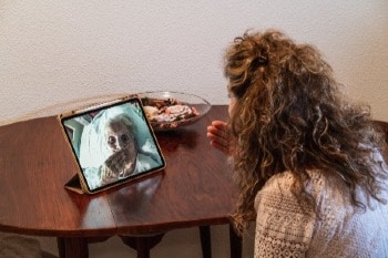 Woman making a video call on a tablet with her mother at the hospital.