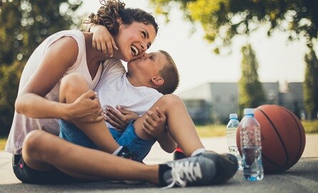 Woman playing basketball with son