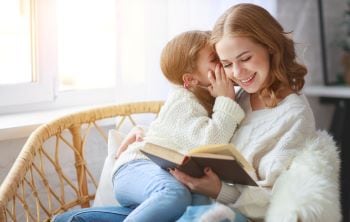 woman reading a book with her child