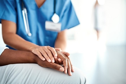 Caregiver holding a patient's hand