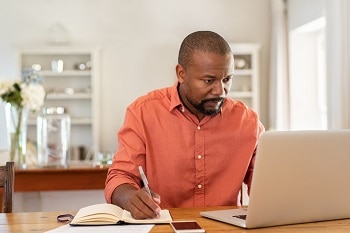 Man taking notes at computer