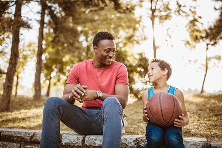 A man and a boy sitting together outside