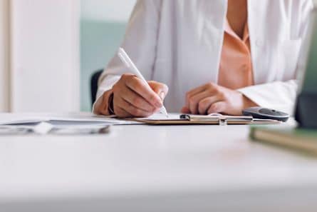 A doctor filling out paper work 