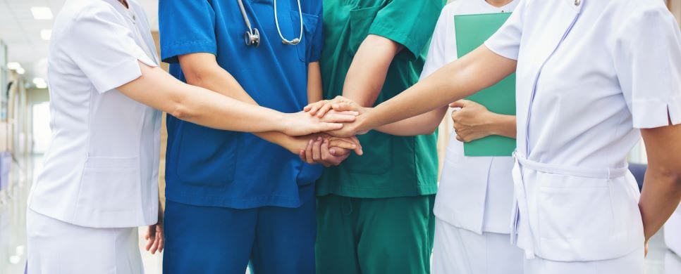 Health care professionals joining hands