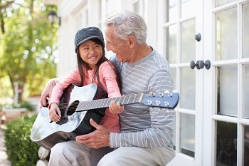 Child playing guitar with grandpa