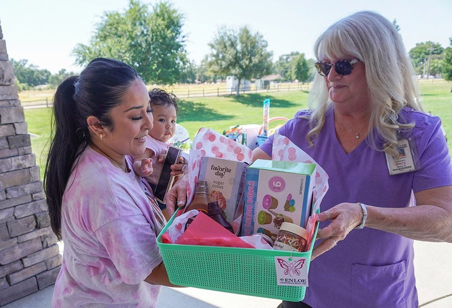 Caregiver giving gift basket to community member