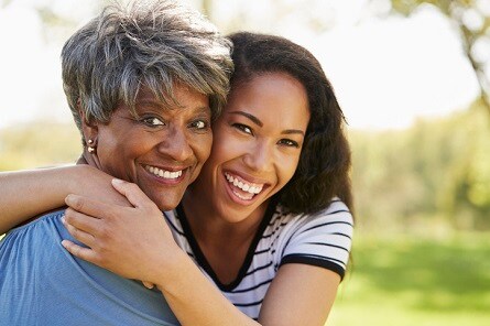 Mother and adult daughter smiling 