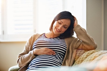 Pregnant woman rubbing her belly. 